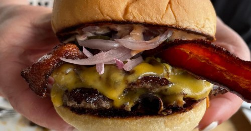 A person holds one of the best burgers in Alabama from Porch, a restaurant in Mountain Brook.
