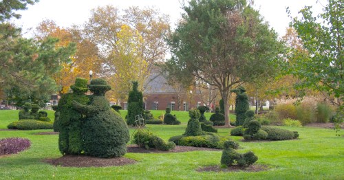 Lush green bushes shaped like people populate the grassy landscape at the Topiary Park in Columbus, Ohio.