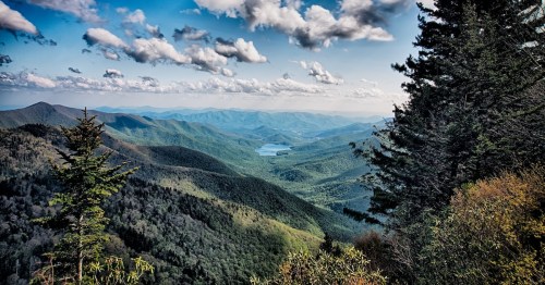 Mountains covered in trees with a blue, cloudy sky in the background at the Great Smoky Mountains in Tennessee