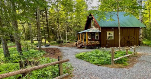 Winter cabin in Idaho in the middle of green forest trees.