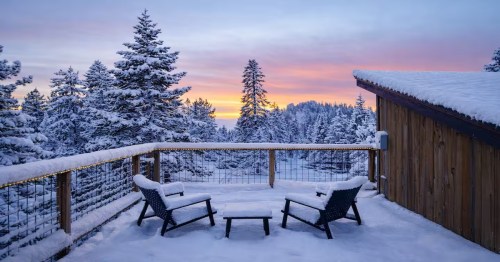 two chairs and a table covered in snow outside on the patio of a winter cabin in Lake Tahoe, Nevada