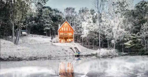 A snow-covered cabin reflects on an icy lake in West Lafayette, Ohio.