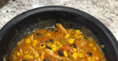 A hearty bowl of chicken tortilla soup filled with corn, black beans, and peppers in a savory broth.