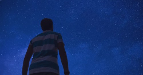 * Stargazing at night: Man gazing at the Milky Way, a breathtaking celestial view.