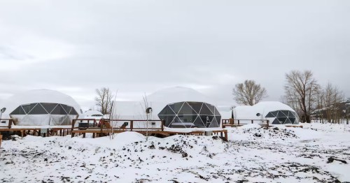 a dome-shaped winter yurt covered in snow in Wyoming