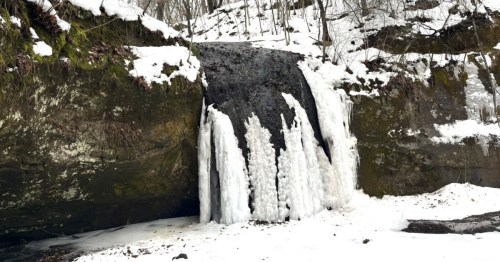 A frozen waterfall curls over the lip of a cliff at Governor Dodge State Park in Wisconsin