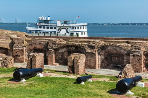 Cannons lay on the ground surrounded by the stone walls of Fort Sumter.