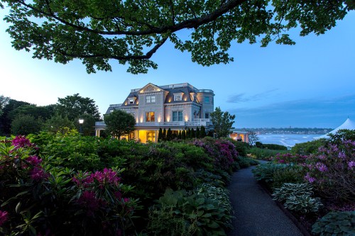 Waterfront Gilded Age mansion at dusk