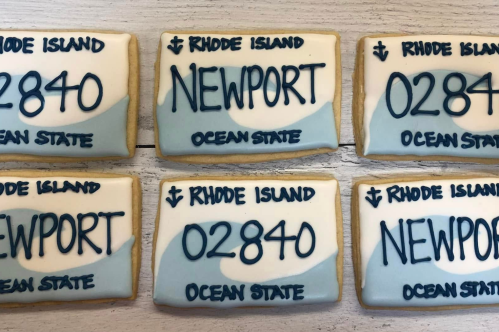 A set of six sugar cookies that look like a RI license plate, some with Newport on them and the others with Newport's zip code.