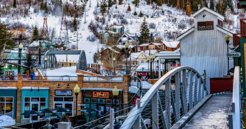 The iconic downtown Park City, Utah with the ski resort right in the backdrop and the sun reflecting through the snow.