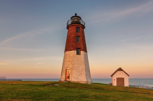 Point Judith Lighthouse stands tall against a colorful sunset sky in Narragansett, Rhode Island.