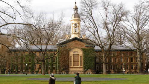 The historic, ivy-covered Nassau Hall at Princeton University under a canopy of bare winter trees.
