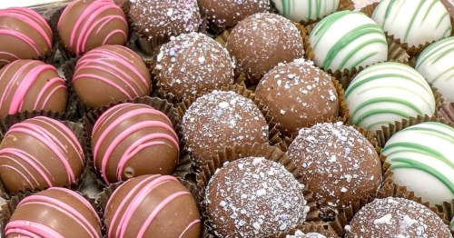Close-up of assorted artisan chocolate truffles with colorful drizzled patterns at Sweet Dreams Confections.