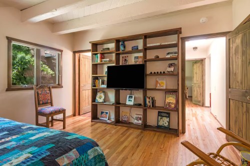 a bookshelf on wood floors in a small romantic airbnb in new mexico