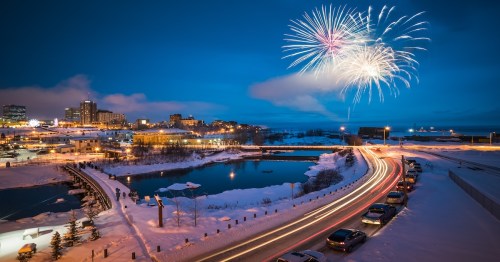 fireworks light up the evening sky in downtown anchorage, alaska during the snowy winter season