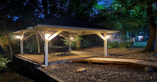 A lit up canopy under trees and above bark in a romantic Airbnb in Arkansas