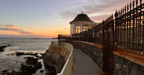 Newport Cliff Walk, Newport, RI: Scenic coastal path at sunset with ocean view and historic architecture.