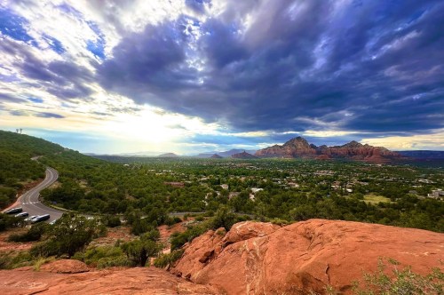 Breathtaking panoramic views of the red rock formations in Sedona, featuring a cloudy sky and vistas of a pretty sunset over the city