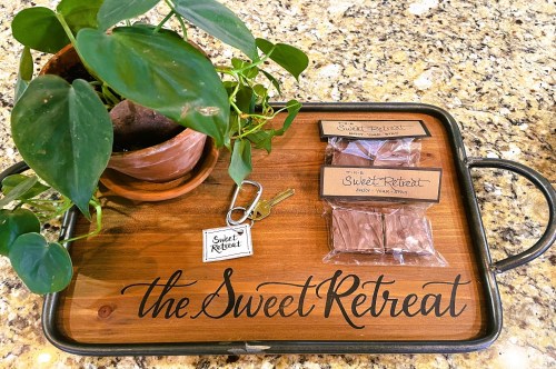 A decorative tray from the Sweet Retreat Airbnb with chocolates and a house plant with large green leaves