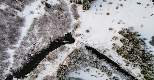 Aerial shot of a gold creek pond in wintertime