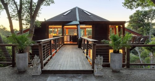 a modern treehouse with a wooden bridge in northern california