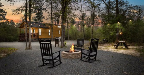 A romantic cabin in Louisiana with a fire pit and string lights.