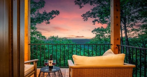 outdoor patio with yellow chair and black table with a sunset in the background