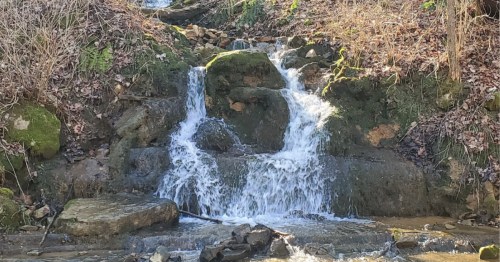 Waterfall over mossy rocks onto a shallow pool in Brandenburg, Kentucky