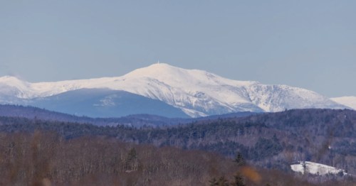 Winter scenery from Knox Mountain summit: Distant, snow-capped mountains and a snow-dusted landscape.