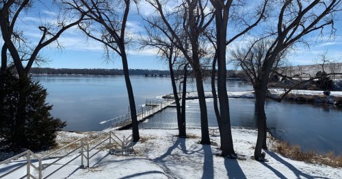 A scenic winter hike in Nebraska with sweeping views of a vast, frozen lake and distant snow-covered ridges.