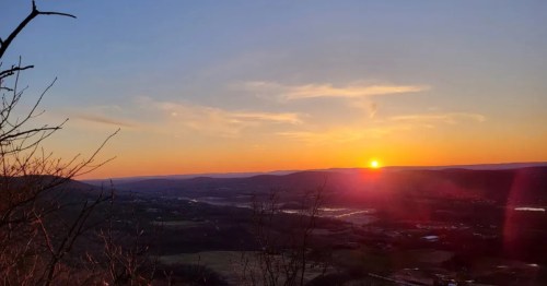 A tall overlook of the mountains at sunset.