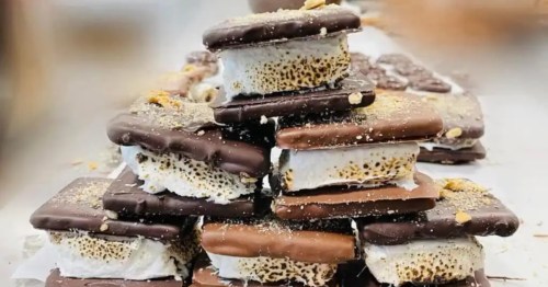 Stacked s'mores with toasted marshmallows, chocolate, and chocolate-covered graham crackers.  
