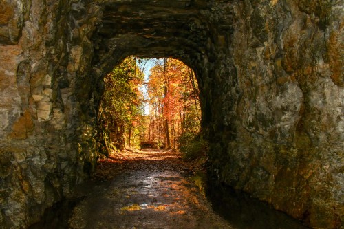 Stumphouse Mountain Tunnel in Oconee County, South Carolina with orange and green trees in the distance