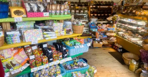 An old-fashioned candy store in CT with fully stocked shelves of gift baskets showcasing a wide variety of candies and treats