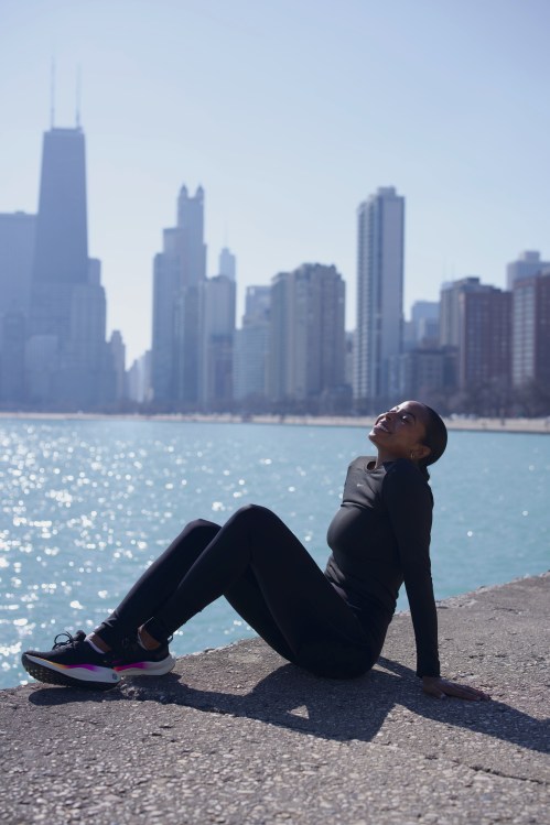 Woman enjoying the sunshine on a lake front trail with cityscape in the background