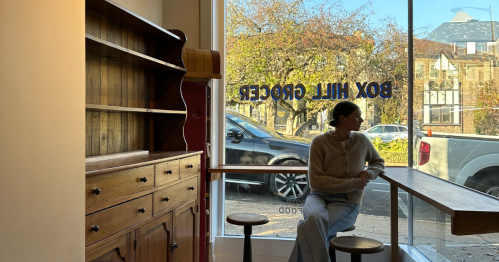 Woman sitting an empty shop looking pensively