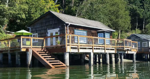 At high tide, the Puget Sound reaches all the way to the beach stairs of this waterfront cabin.