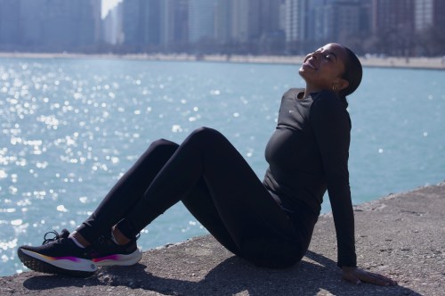 Woman enjoying the sunshine on a lake front trail with cityscape in the background