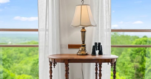 A table with a lamp and a pair of binoculars at a treehouse Airbnb in Indiana.