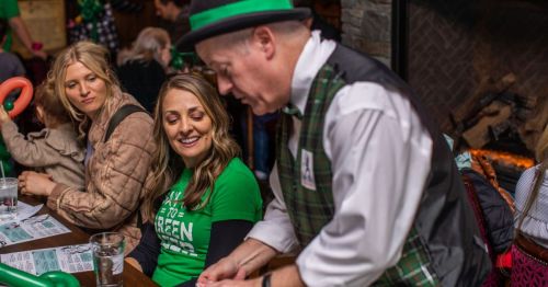 A lively St. Patrick's Day scene at an authentic Irish pub in Washington with a magician cutting a deck of cards.
