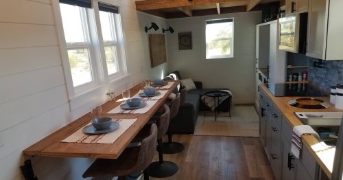 four bar stools under a wooden ledge in a tiny kitchen in arizona