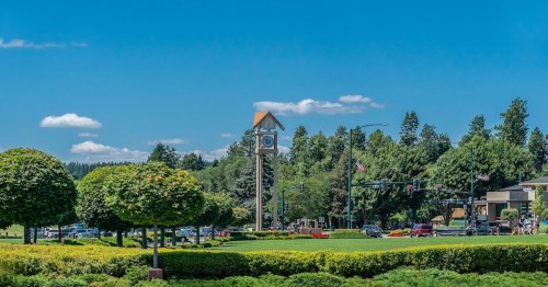 a large clock tower in the middle of a grassy green park in idaho