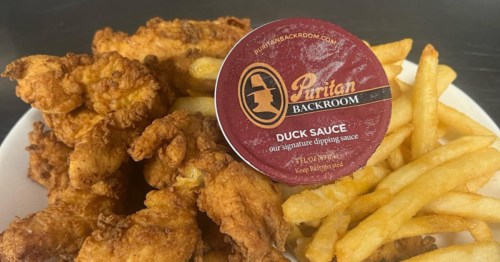 A plate of chicken tenders and french fries with a container of duck sauce at the Puritan Backroom restaurant in Manchester, NH.
