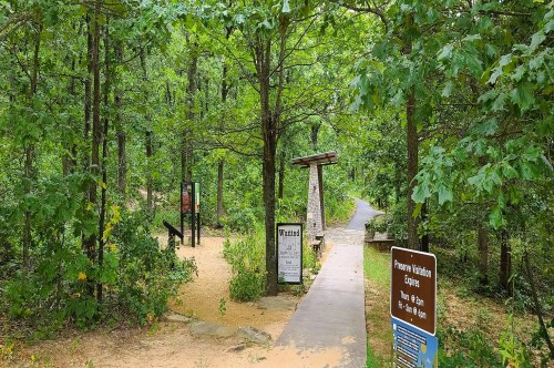 A wooded area along an ADA accessible paved trail inside Keystone Ancient Forest in Oklahoma