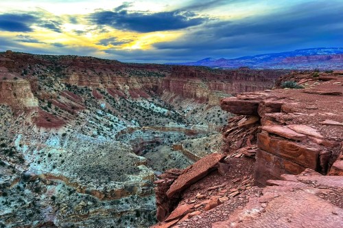 Views of a golden sunset behind the clouds over the canyons at Capitol Reef National Park in Utah