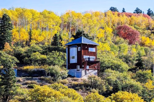 A lighthouse Airbnb in Utah nestled inside a heavy forested area with colorful trees