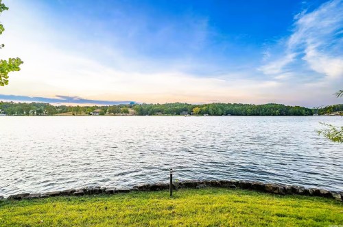 Scenic views of Lake Hamilton in Arkansas with houses and lush greenery in the distance on a partially cloudy day