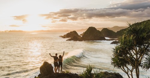Couple enjoying sunset with amazing ocean and mountain view