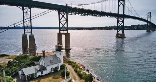 The Bristol Ferry Lighthouse overlooks the Mount Hope Bridge and Narragansett Bay in Bristol, Rhode Island.