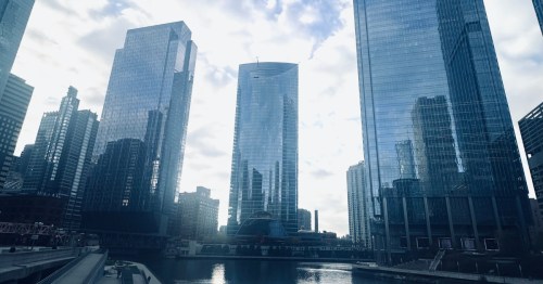 Glass skyscrapers tower over a river during a cool spring break in Chicago, Illinois.